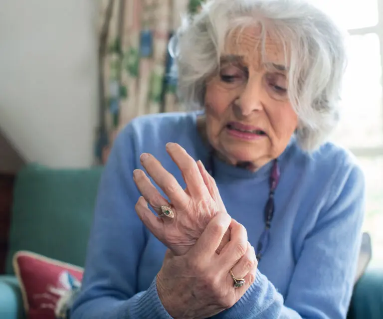 Frau mit schmerzenden Gelenken, hält Hand