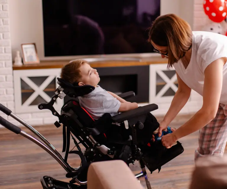 Mutter versorgt ihr schwerbehindertes Kind im Rollstuhl
