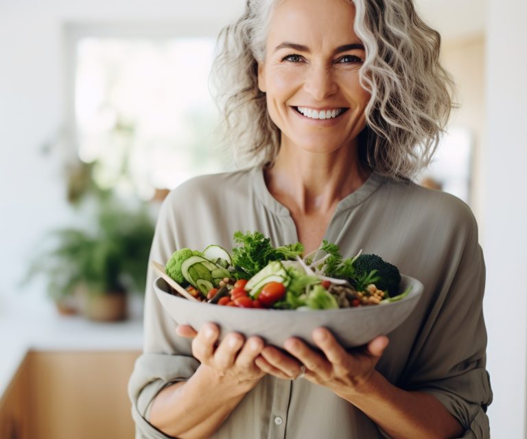 Lächelnde Frau hält Salatschüssel in der Hand