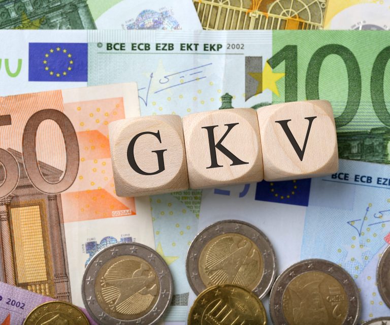 Würfel mit Schriftzug GKV auf Geldscheinen