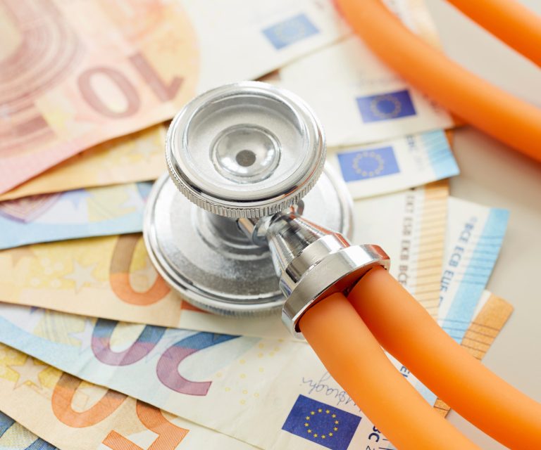 Ein Stethoskop liegt auf mehreren Euro-Scheinen