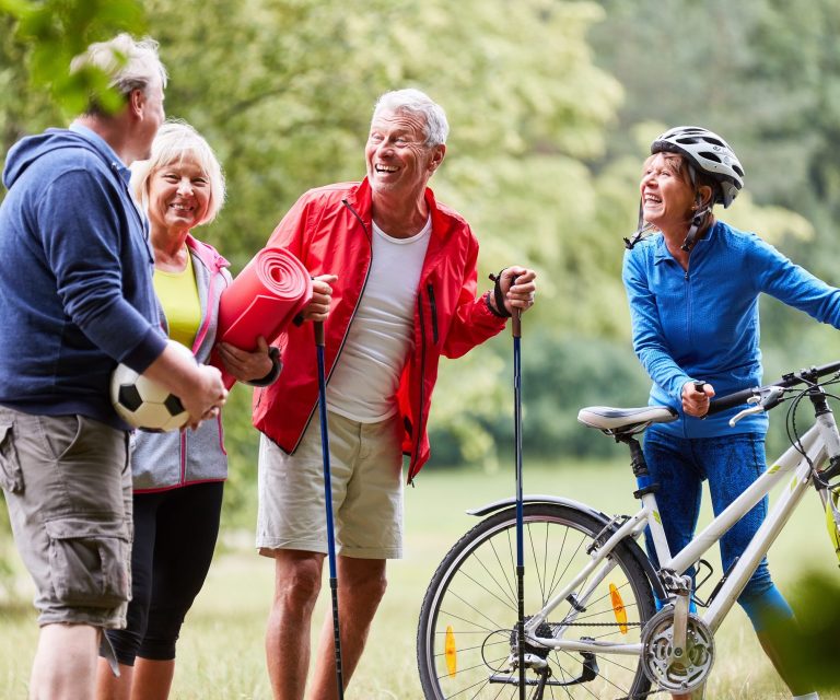 Aktive Senioren machen zusammen Fitness in der Natur.